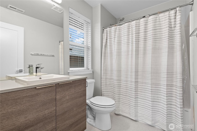 bathroom featuring toilet, a shower with curtain, visible vents, and vanity