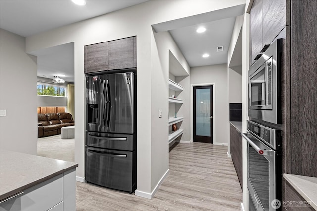 kitchen featuring light wood-style flooring, modern cabinets, appliances with stainless steel finishes, and light countertops