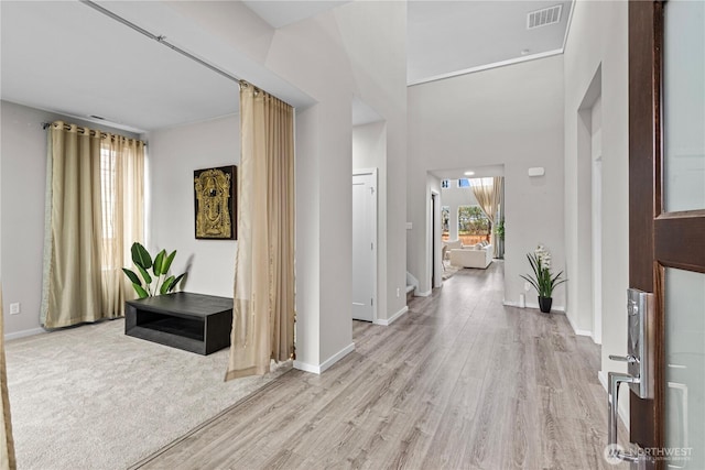 entryway with light wood-style flooring, visible vents, and baseboards