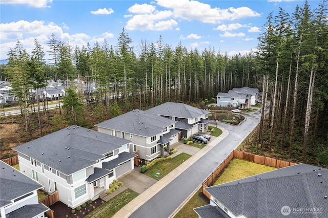 drone / aerial view featuring a residential view and a wooded view