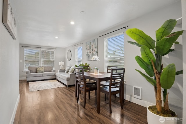 dining space featuring baseboards, wood finished floors, visible vents, and a healthy amount of sunlight