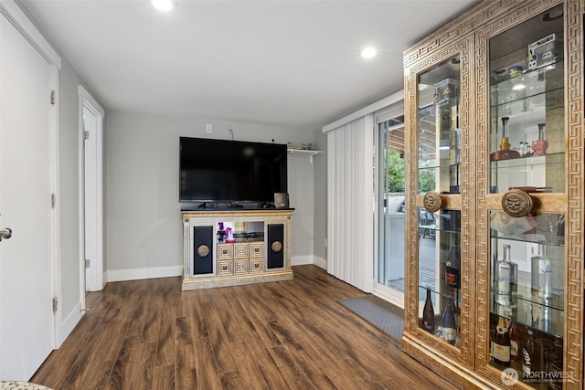 living area featuring baseboards, wood finished floors, and recessed lighting