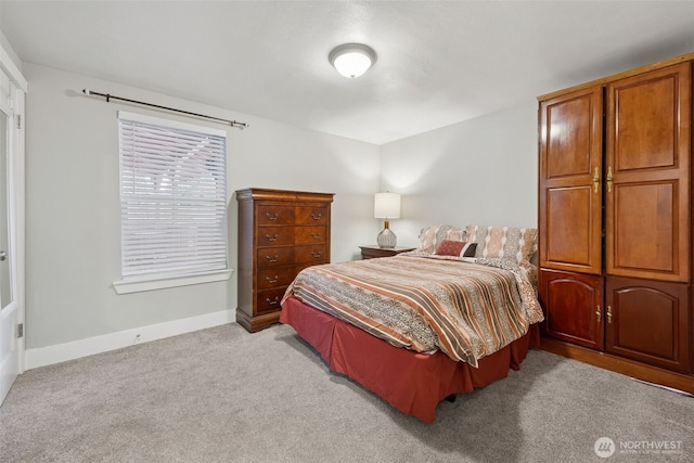 bedroom with light colored carpet and baseboards