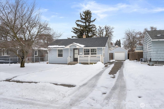 view of front of property with a chimney, a detached garage, fence, and an outbuilding