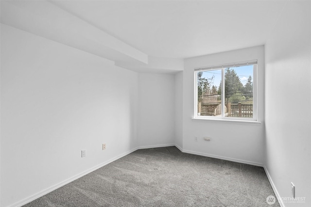 carpeted empty room featuring baseboards