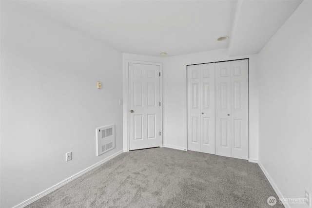 unfurnished bedroom featuring carpet floors, baseboards, visible vents, and a closet