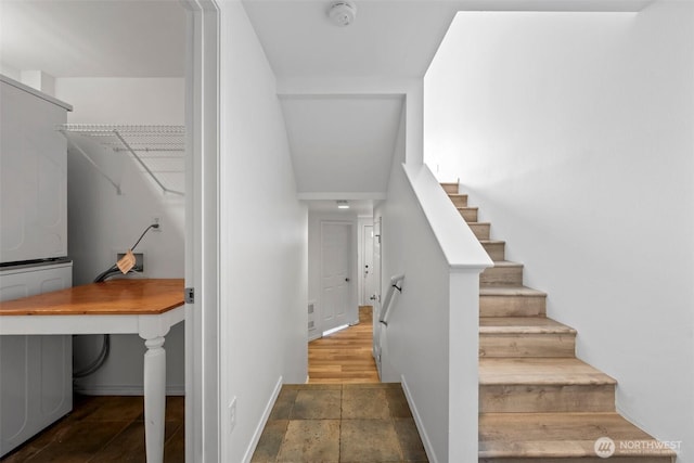 stairs featuring stone finish floor and baseboards