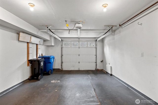 parking garage with a garage door opener and baseboards