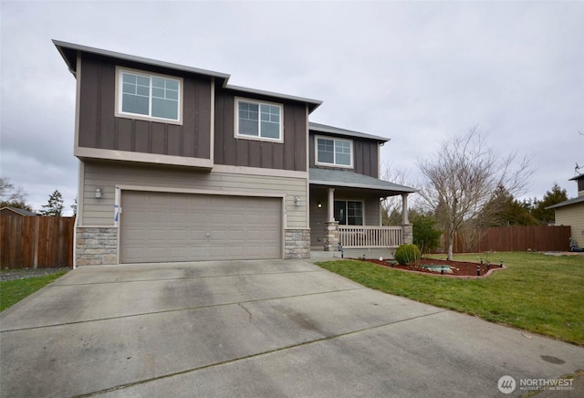 view of front of property featuring board and batten siding, a front lawn, fence, covered porch, and stone siding