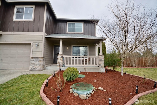 craftsman house featuring fence, a porch, an attached garage, stone siding, and board and batten siding