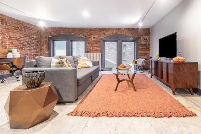 living room featuring brick wall and track lighting