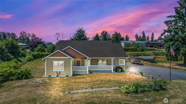 view of front of home featuring aphalt driveway, covered porch, crawl space, fence, and a front lawn