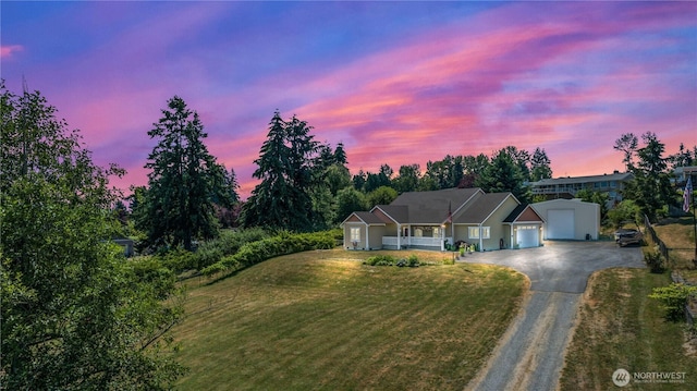 single story home with a porch, a garage, driveway, and a front lawn