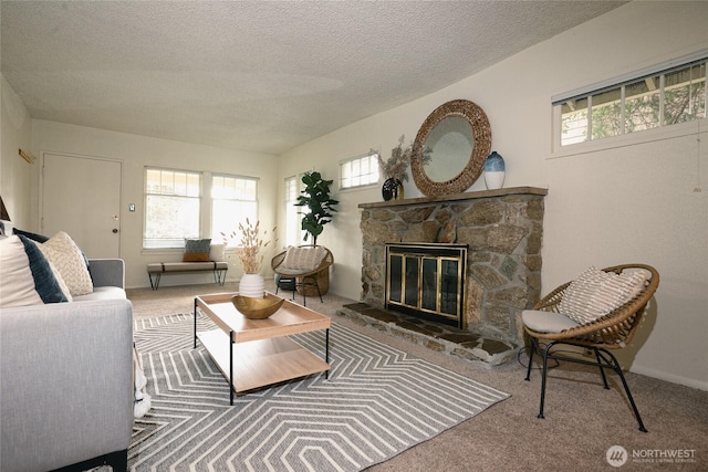 carpeted living room with a textured ceiling, a stone fireplace, and a healthy amount of sunlight