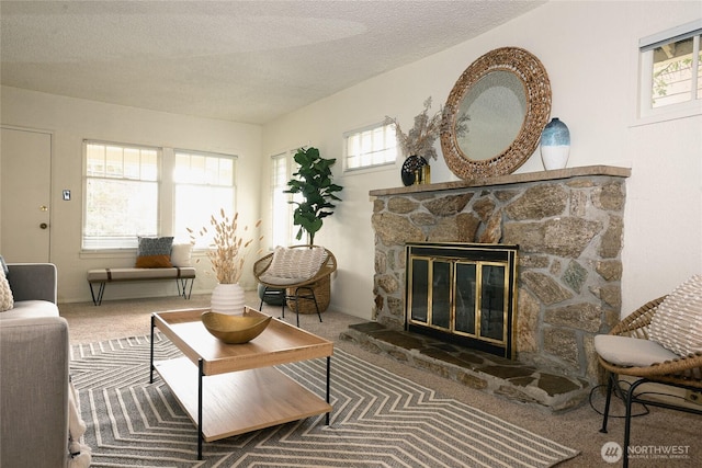 living room featuring carpet floors, a fireplace, and a textured ceiling