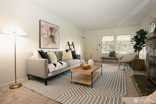 living area featuring a textured ceiling, carpet floors, and a fireplace