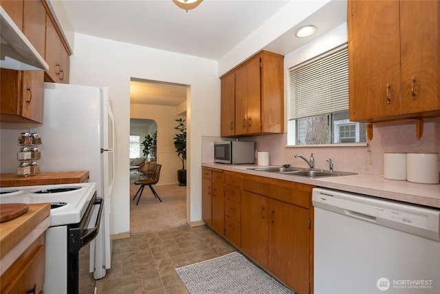 kitchen with light countertops, white appliances, extractor fan, and a sink