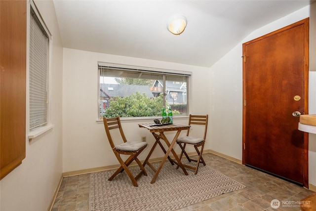 dining room with vaulted ceiling and baseboards