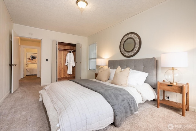 bedroom featuring a closet, light carpet, and a textured ceiling