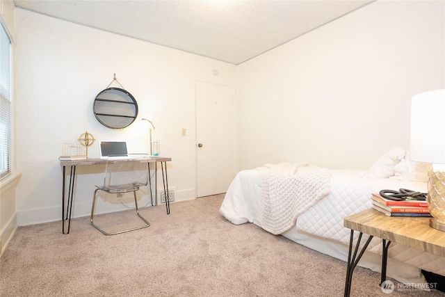 bedroom with a textured ceiling, baseboards, visible vents, and light colored carpet