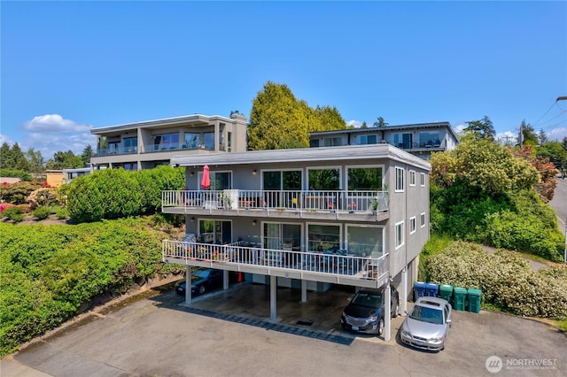 rear view of house with uncovered parking and a balcony