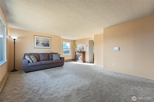 carpeted living area featuring baseboard heating, a textured ceiling, and a glass covered fireplace