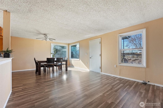 dining space with a textured ceiling, wood finished floors, and a wealth of natural light