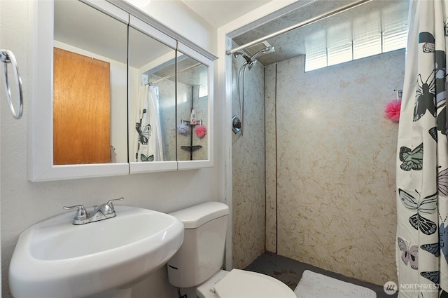 full bath with toilet, a shower with curtain, and a sink