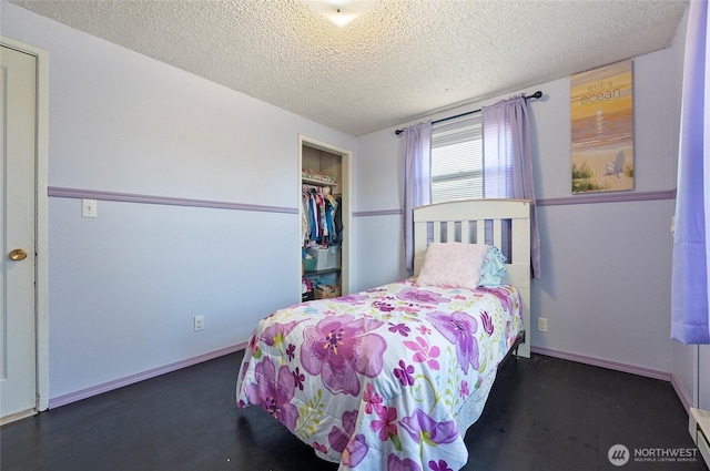 bedroom with a baseboard radiator, a closet, a textured ceiling, and baseboards