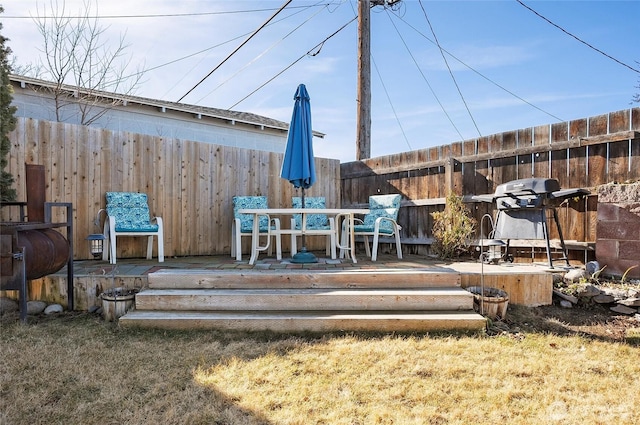 wooden terrace with a lawn, area for grilling, and fence