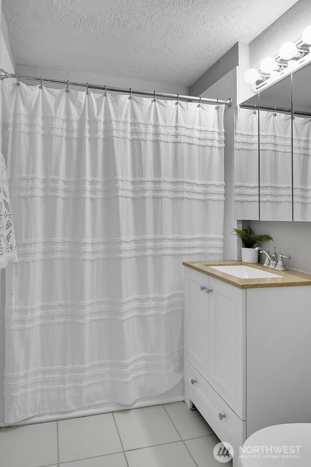 5122 S Brighton St, Seattle, WA 98118 - full bath with a shower with shower curtain, tile patterned floors, vanity, and a textured ceiling