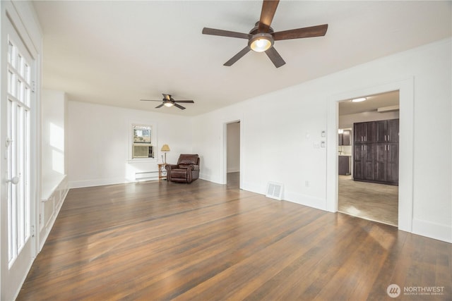 spare room with visible vents, baseboards, and dark wood-style flooring