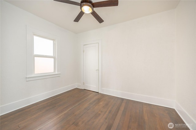 unfurnished room with dark wood-style floors, ceiling fan, and baseboards