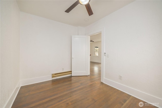 spare room with ceiling fan, a baseboard radiator, dark wood finished floors, and baseboards