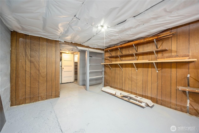 unfinished basement featuring wood walls