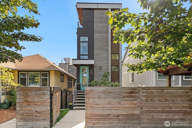 contemporary house featuring fence