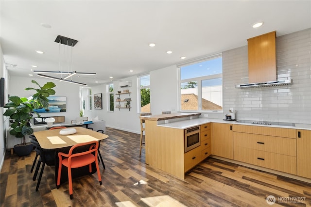 6610 Corson Ave S, Seattle, WA 98108 - kitchen featuring a wall mounted AC, wood finished floors, stainless steel microwave, light brown cabinets, and wall chimney exhaust hood