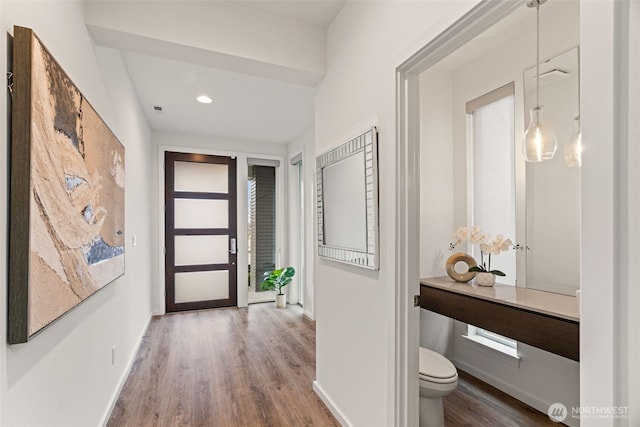 hall featuring recessed lighting, wood finished floors, and baseboards