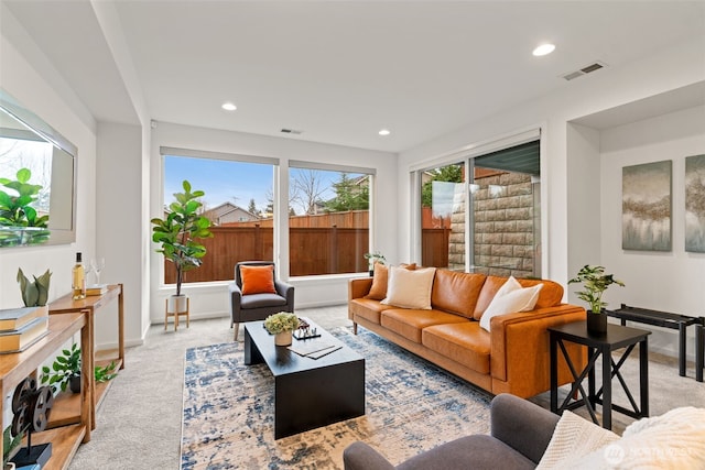 living area featuring light colored carpet, visible vents, baseboards, and recessed lighting