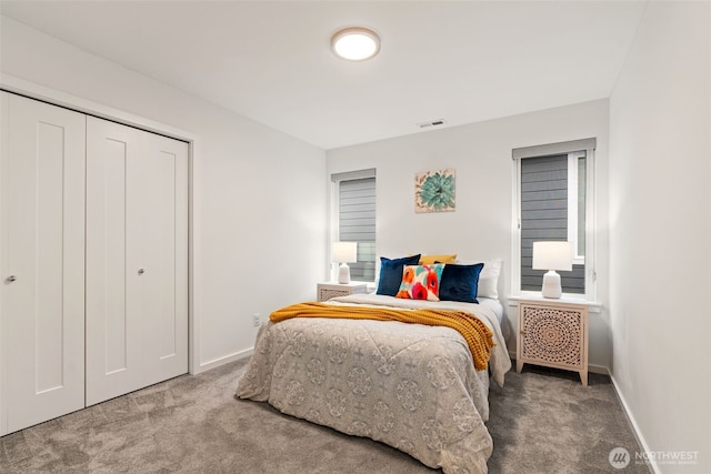 carpeted bedroom with a closet, visible vents, and baseboards