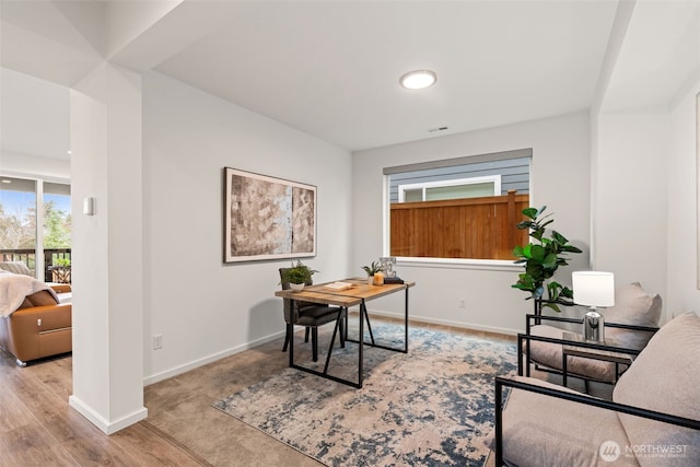 office space featuring visible vents, baseboards, and wood finished floors