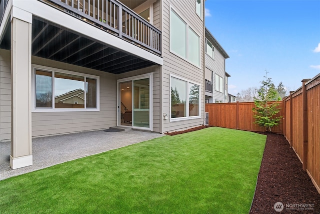 rear view of house with a patio area, a fenced backyard, and a lawn