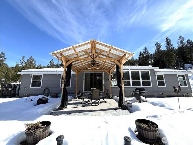 snow covered property with crawl space and a pergola