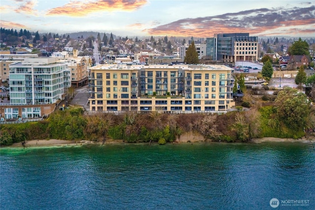 aerial view at dusk with a water view and a city view