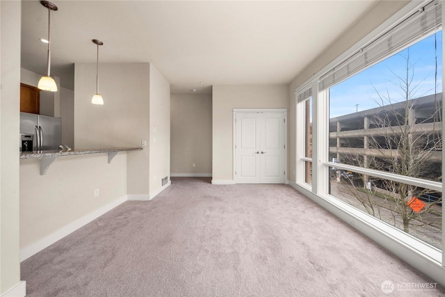 unfurnished room with light carpet and baseboards