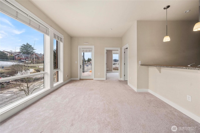 empty room with baseboards and light colored carpet