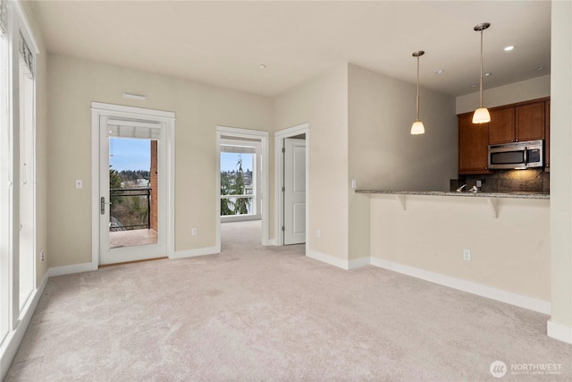 interior space with light carpet and baseboards