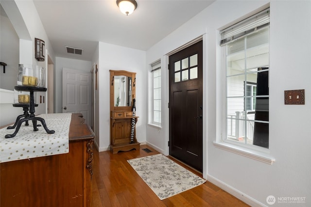 foyer featuring wood finished floors, visible vents, and baseboards