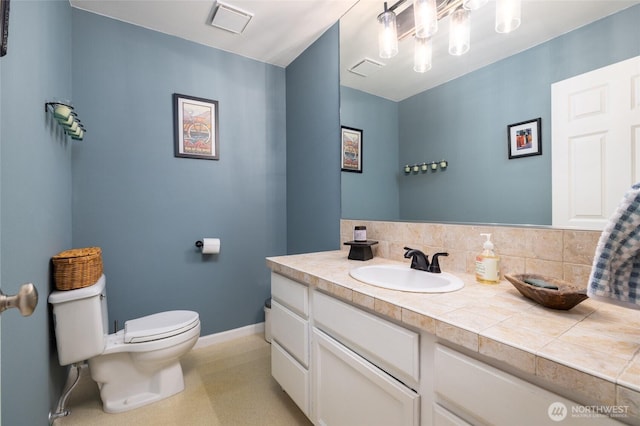 bathroom with visible vents, baseboards, vanity, and toilet