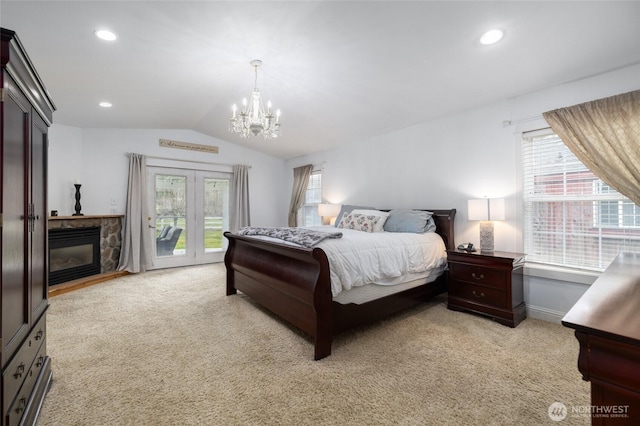 bedroom with light colored carpet, vaulted ceiling, a stone fireplace, and multiple windows